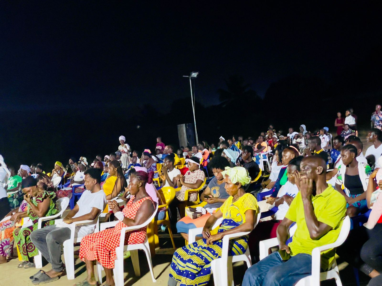 Open-air gospel meeting with attendees seated outdoors