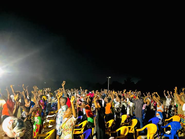 Preacher ministering from a crusade stage at night